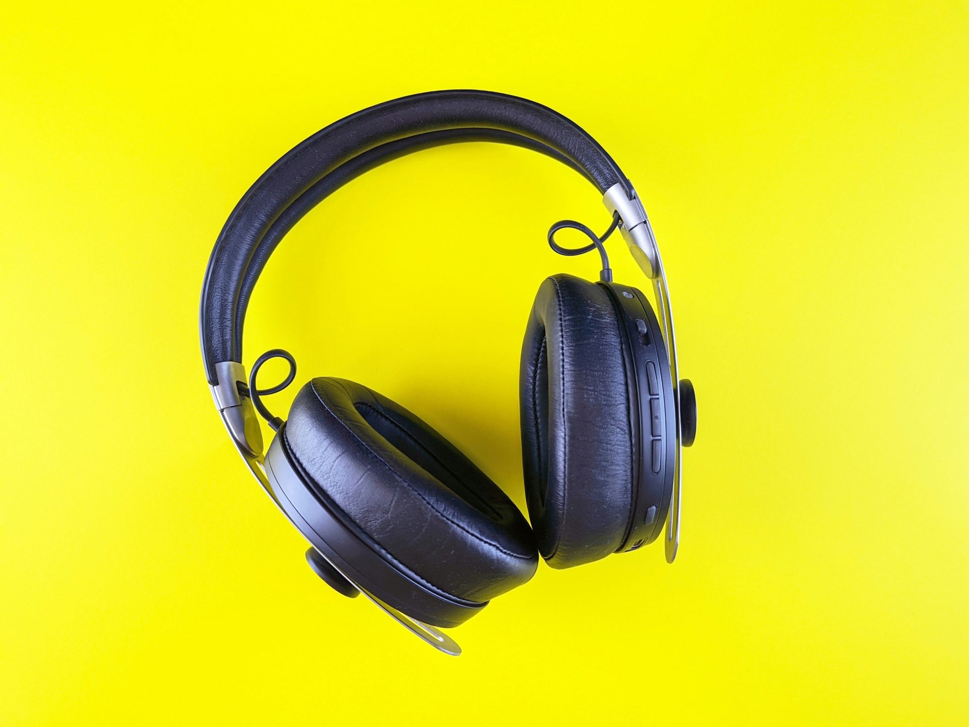 Black headphones on a vibrant yellow backdrop.